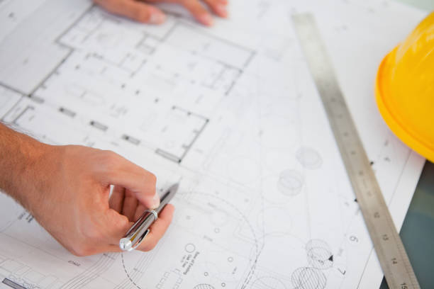 istock Close up of blueprints with a person making adjustments 842203554