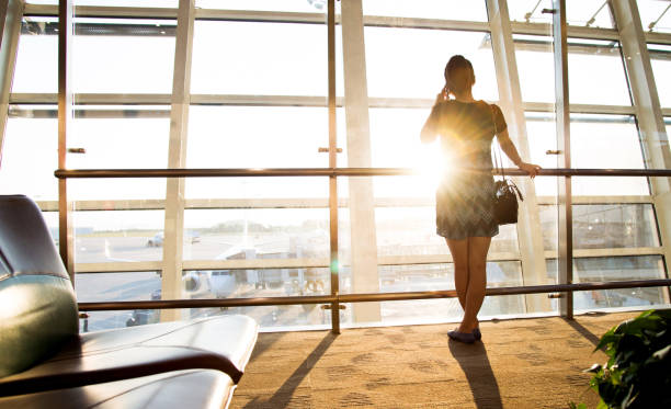 istock Young woman talking on mobile phone at airport 842209414