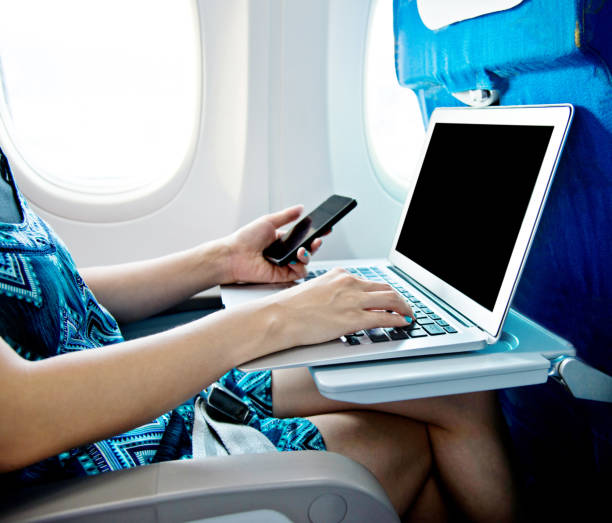 istock Woman using smart phone and laptop on airplane 842209560