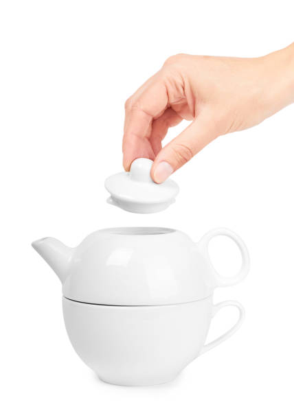 istock white ceramic kettle or teapot with cup in hand. Isolated on white background 842209734
