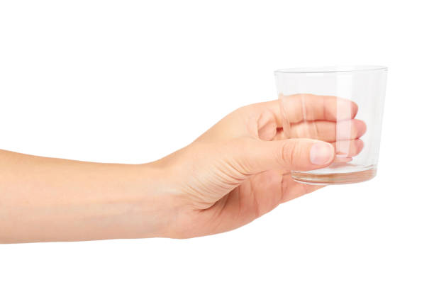 istock female hand holding transparent glass cup. Isolated on white background 842209766