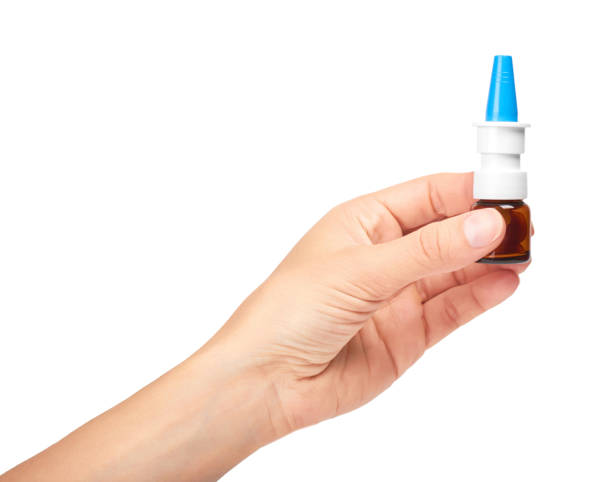 istock female hand holding nose spray bottle. Isolated on white background 842209958