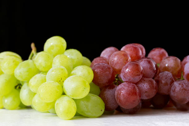 istock Fresh grapes on a white table and black background. 842211506