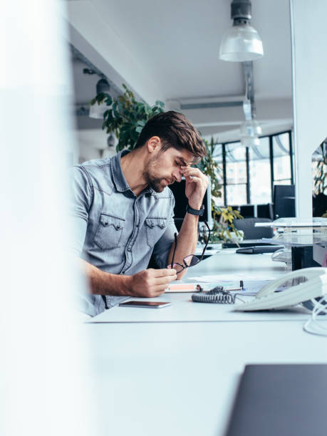 istock Tired young businessman in the office 842220796
