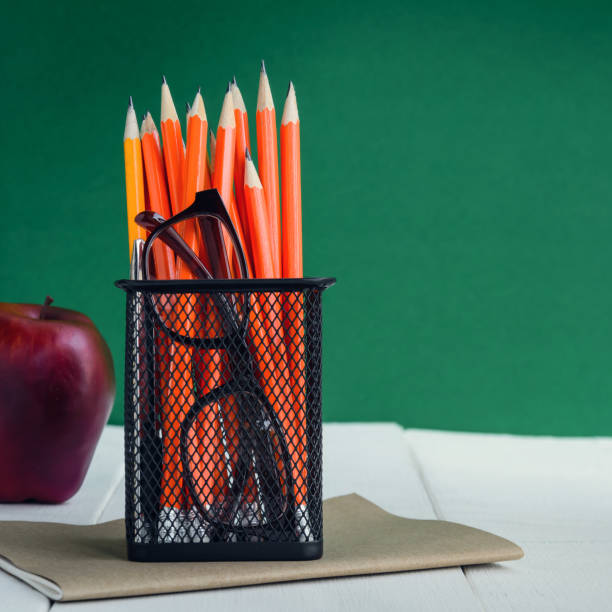 istock Books Pencil and apple on a white wooden table 842225274