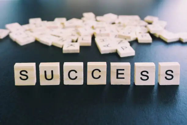 Photo of Success word on wood block with black backgrounds