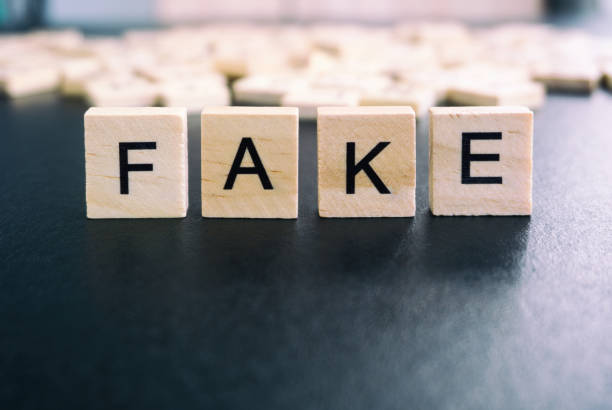 istock Fake word on wood block with black background 842231438
