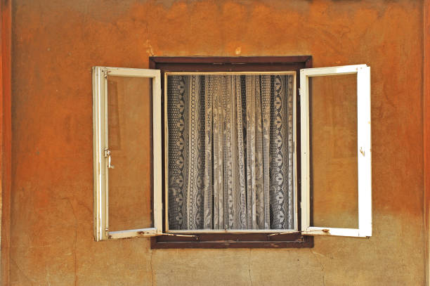 Tulle in the window frame of stone house