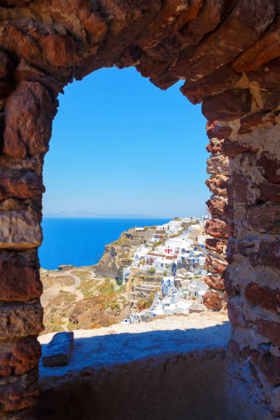 istock Windmill through an old stone window in Santorini island, Greece 842247182