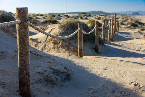 Rope fence on the sandy beach of La Mata. Sunset on the beach. Blurred unfocused background