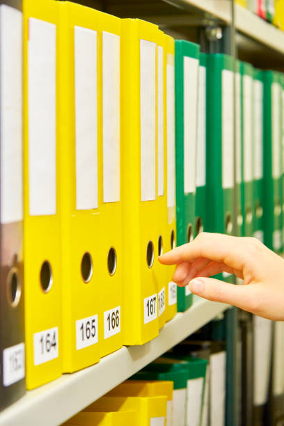 緑・黄・黒のファイル フォルダー アーカイブおよび人間手のそれらの選択の 1 つ - ring binder file green document ストックフォトと画像