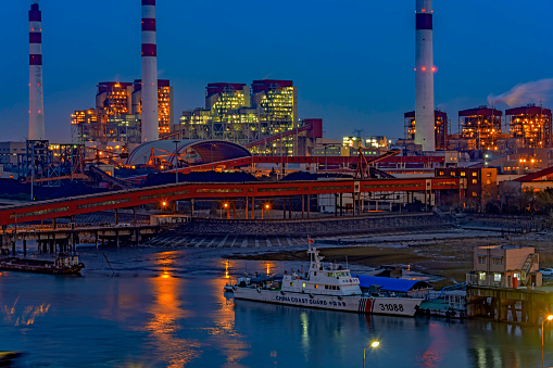 Shanghai: Chinese Coast Guard (CCG) offshore patrol vessel No. 31088 berthed at the pier next to China's Biggest coal-fired power plant in Shanghai at twilight.
