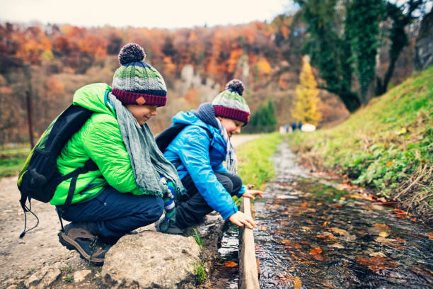 istock Boys observing a stream with autumn leaves 842285292