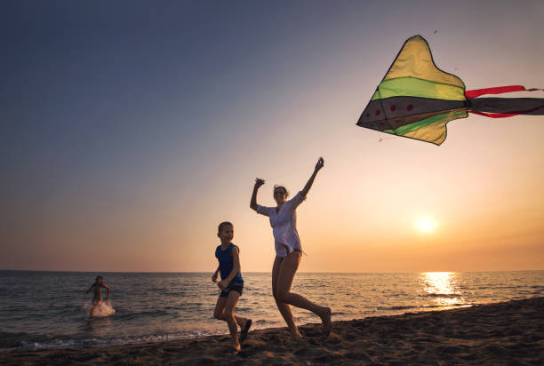 istock Mother and child flying kite at beach 842286014