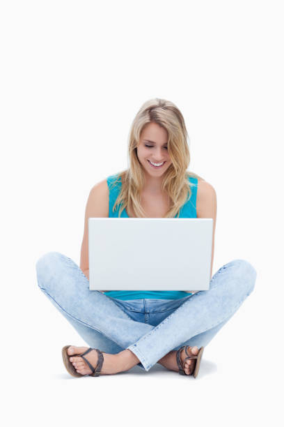 istock A woman is sitting on the ground looking at her laptop 842286310