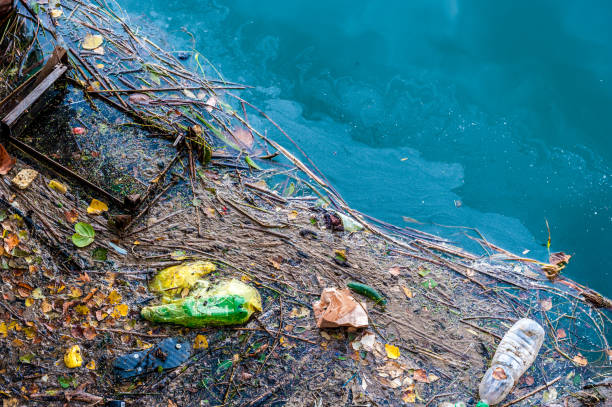 Water pollution old garbage and oil patches on river surface stock photo