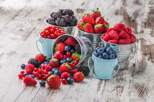 istock Berries mix in tin cans on white rustic wooden table 842289552
