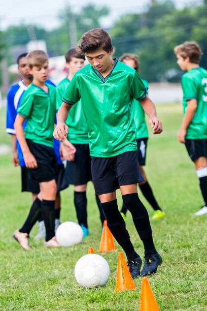 istock Confident soccer player kicks ball around practice cones 842290056