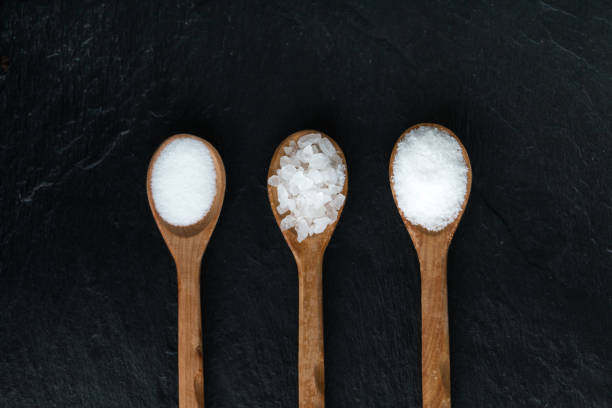 istock Different types of salt. Top view on black in wood spoons. Copy space. 842295870