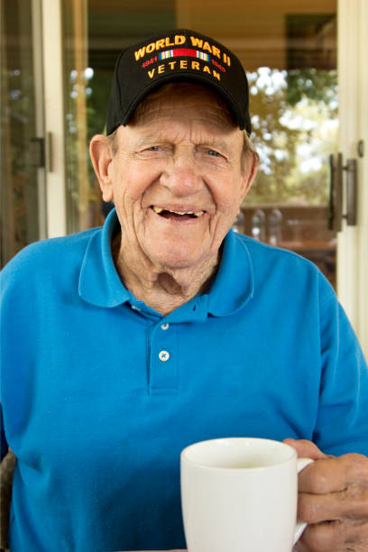 istock World War Two Veteran wearing WW2 cap smiling holding coffee cup 842305288