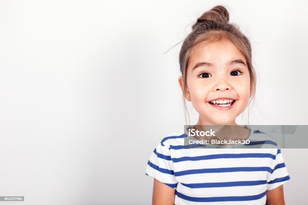 Happy Small Girl Happy small girl on the grey light background in the studio. Smiling Stock Photo