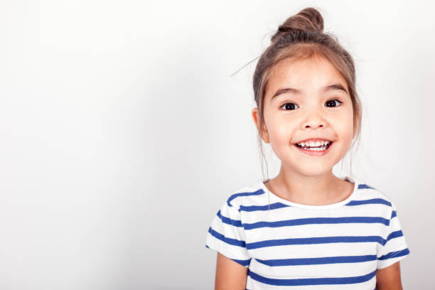 Happy Small Girl Happy small girl on the grey light background in the studio. smiling kids on white stock pictures, royalty-free photos & images