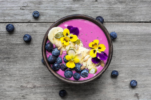 istock Smoothie bowl with fresh berries, nuts, seeds and flowers 842317660
