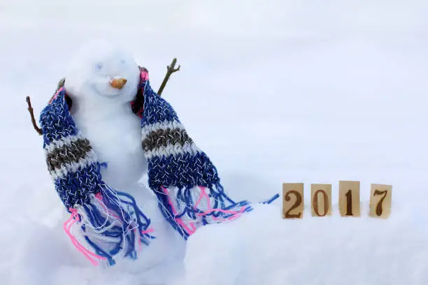 smiling snowman in the scarf next to numbers in the snowdrift