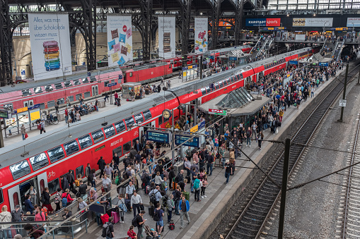 Passengers are waiting at the central train station of Hamburg. S Bahn, U Bahn, regional trains and international trains stop at this central train station.