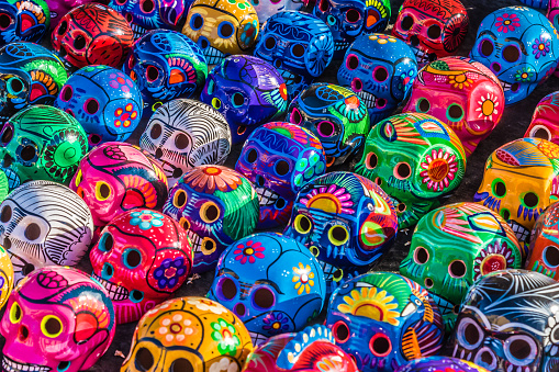 Mexican Culture Fiesta: Colorful (colourful) traditional Mexican/hispanic ceramic pottery Day of the Dead (Dia de los Muertos) skulls on display at a market in Mexico.