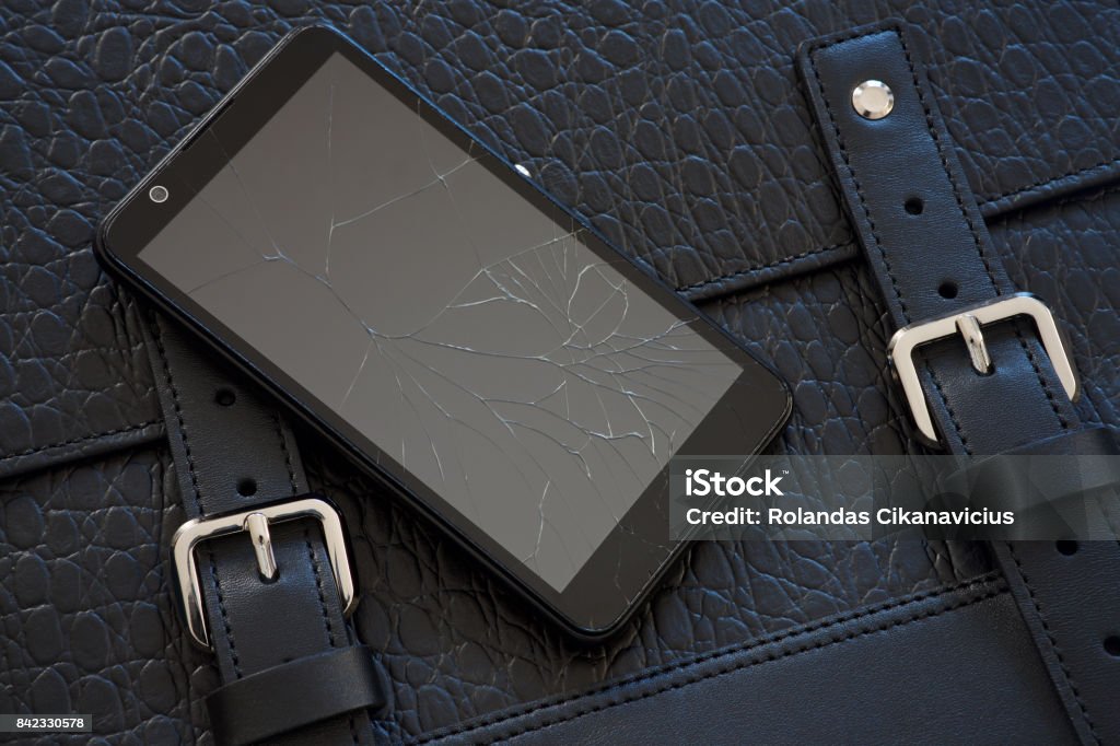 Broken glass of smart phone on leather bag Broken glass of smart phone on the black leather bag Buster Posey Stock Photo