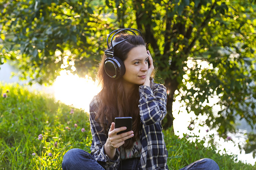 Girl in headphones in the park, sunset,