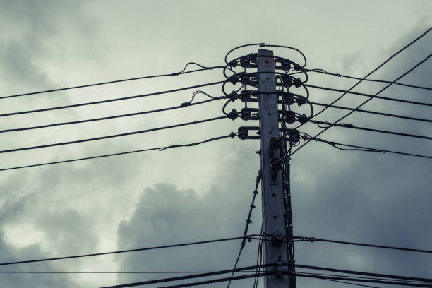 istock High voltage power pole with wires tangled on building behind. 842363272