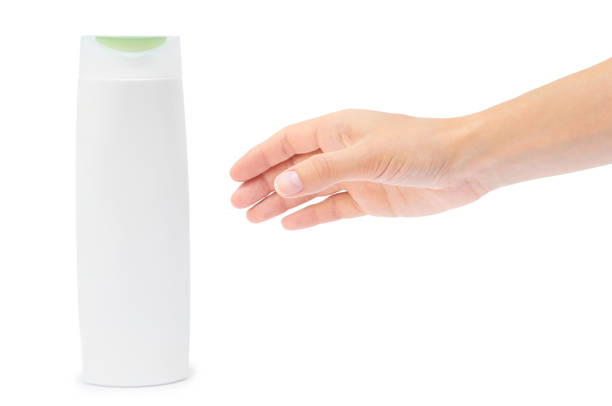 Hand holding shampoo bottle isolated on white background