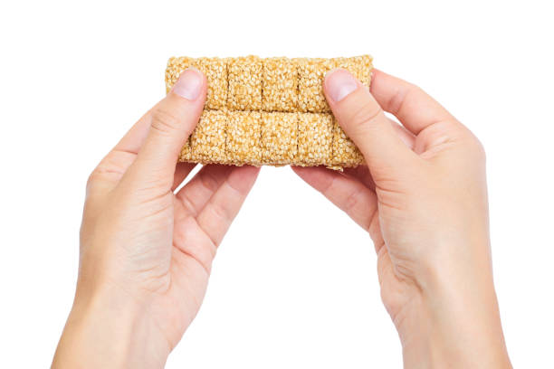 sesame brittles brick in hand Isolated on white background