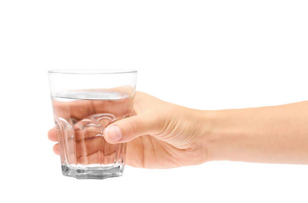 female hand holding glass cup. Isolated on white background stock photo