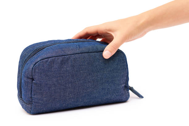 istock female hand holding cosmetic bag. Isolated on white background 842369734
