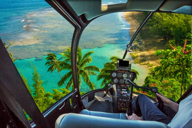 Kauai scenic flight Helicopter cockpit flies in Kee Beach, Kauai, Hawaii, United States, with pilot arm and control board inside the cabin. flight instruments stock pictures, royalty-free photos & images