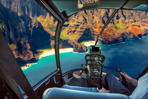 Na Pali Coast scenic flight Helicopter cockpit flies in Na Pali coast, Kauai, Hawaii, United States, with pilot arm and control board inside the cabin. flight instruments stock pictures, royalty-free photos & images