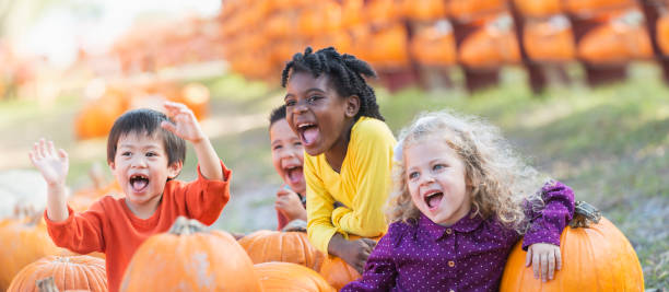 istock Four multi-ethnic children with lots of pumpkins 842376140