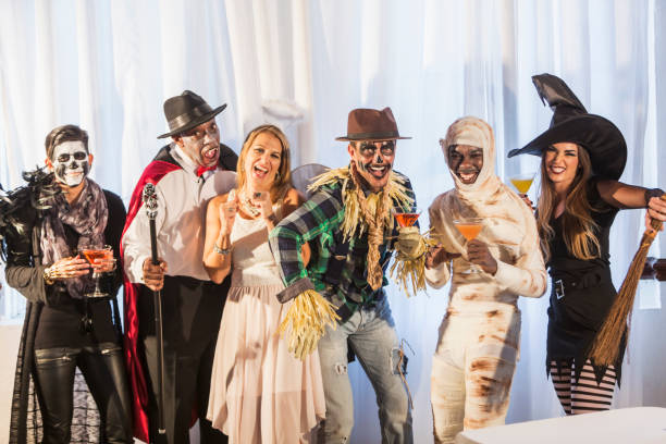 Adult halloween party A multi-ethnic group of six men and women at an adult halloween party with alcoholic beverages.  The costumes include an vampire, angel, witch, scarecrow, mummy and zombie. costume stock pictures, royalty-free photos & images