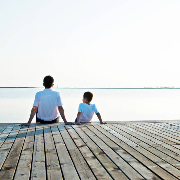 istock Father with his son enjoying lake view 842379092
