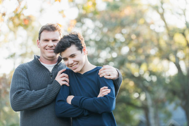 père et adolescent debout à l’extérieur - parent teenager caucasian teenage boys photos et images de collection