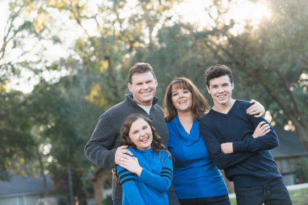 istock Family of four standing in front yard 842379130