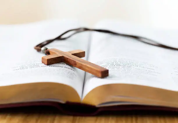 Photo of Bible and cross on desk