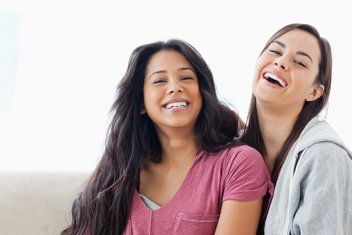Head and shoulder shot of two laughing women looking into the camera