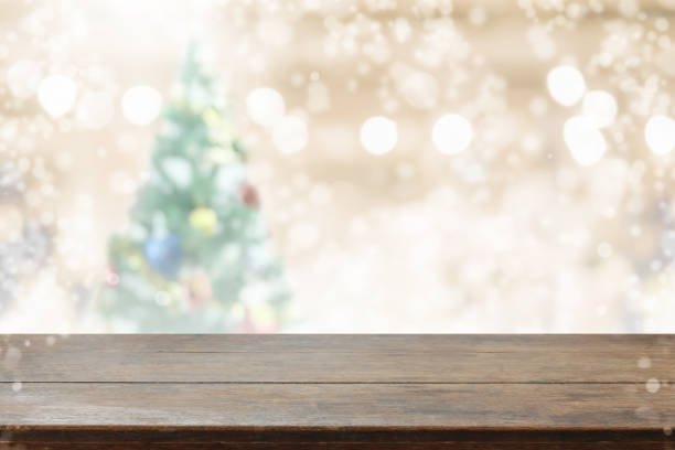 istock Wood table top on blur with bokeh christmas tree background with snowfall - can be used for display or montage your products 842389472