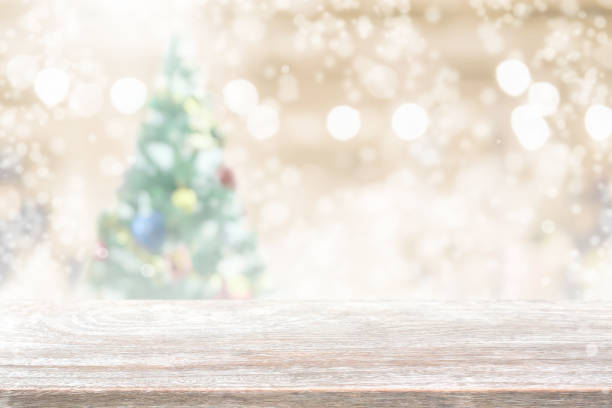 istock Wood table top on blur with bokeh christmas tree background with snowfall - can be used for display or montage your products 842389524