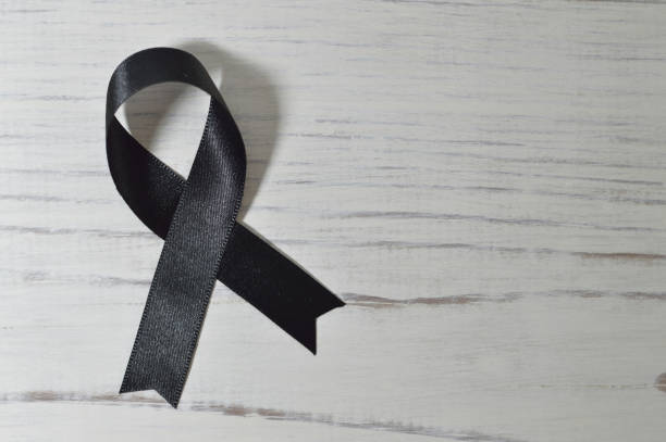 istock black ribbon with white wooden background 842392366