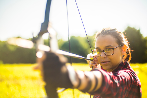 The teenager girl practicing archery in the meadows, Poconos region, Pennsylvania, USA